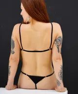 Tanga negra de tiro bajo con tiras finas ajustables.