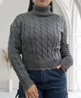 Sweater gris de punto trenzado, con cuello alto y terminaciones rotas.