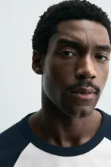 Camiseta de corte relajado con cuello redondo y mangas largas tipo raglán en contraste de color.