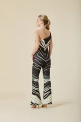 Mono de un solo hombro con estampa animal print en tonos tierra, oliva y negro. Confeccionado en jersey de poliéster y elastano, presenta un corte ajustado al cuerpo con pierna levemente acampanada desde la rodilla y detalle de hebilla dorada en el hombro.