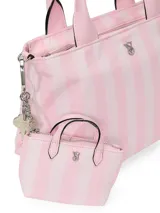 Charm en forma de mini bolso con diseño de rayas rosadas y blancas, cierre de cremallera superior, asas de mano y llavero metálico con gancho.