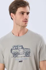 Remera Legacy de manga corta y cuello redondo, color azul melange, con estampa frontal y detalles bordados de un vehículo todoterreno acompañados por el texto "The Adventure Club".