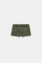 Shorts mini color verde militar, de tiro medio con trabillas, bolsillos delanteros y traseros. Cierre frontal con cremallera, botón interior y gancho metálico.