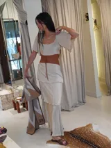 Vestido largo de dos piezas color lila con rayas verticales. El top es de corte cuadrado con mangas cortas acampanadas y elástico en la cintura. La falda es larga con volados y detalles de cuero.