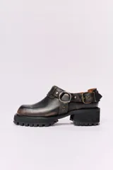Zapato de cuero negro con hebilla y plataforma con suela track.