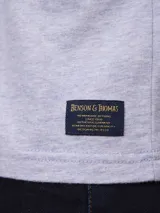 Remera gris de algodón con cuello redondo y estampado pequeño en el pecho.