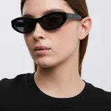 Gafas de sol Mara con montura ovalada negra y lentes polarizadas negras.