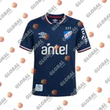Camiseta de fútbol Umbro del Club Nacional de Football, modelo Away 2. Diseño en azul marino con tramado sutil de líneas onduladas, detalles en rojo, blanco y azul en el cuello y los puños. Incluye el logo de Umbro, el escudo del club y el sponsor Antel en el pecho.
