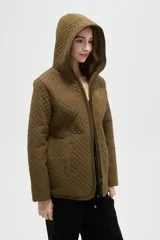 Campera de diseño capitoneado con cierre frontal, capucha integrada y bolsillos laterales. Presenta un corte entallado y mangas largas.