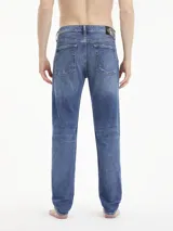 Jeans de algodón elástico, lavado a la piedra azul oscuro, con talle medio y pierna estrecha en el tobillo. Presenta roturas en ambas piernas.