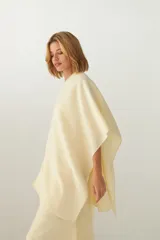 Ruana de lana fina sin teñir, con textura acanalada y terminaciones tejidas a crochet hechas a mano.
