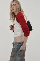 Camiseta de manga larga con cuello redondo, corte regular fit. Color blanco con mangas raglán rojas. Estampado frontal de Kermit the Frog y el texto "Kermit the Frog" en rojo.