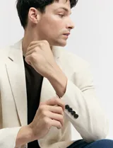 Saco beige de lino con corte clásico, solapas de muesca, cierre de dos botones, bolsillos laterales con solapa y bolsillo en el pecho.