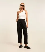 Pantalón zanahoria de sastrería color negro, con cintura alta, pliegues y botones decorativos en los laterales.