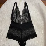 Body negro de encaje con escote en V pronunciado y breteles regulables.