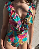 Malla enteriza con estampado de hojas en tonos turquesa, rosa, marrón y violeta. Tiene escote en V con volados y lazo ajustable en el centro.