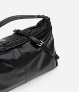 Cartera tipo hobo de gran tamaño confeccionada en poliuretano color negro, con acabado liso y brillante. Presenta un diseño de media luna con cierre superior de cremallera, correa de mano fija y asa larga desmontable. Incluye un detalle de cremallera lateral que permite expandir su capacidad interna.