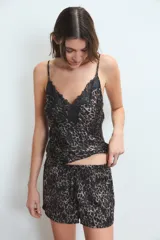 Conjunto de pijama de satén con estampado animal print. Incluye un top de tirantes finos con detalle de puntilla negra en el escote y un short con cintura elástica y lazo ajustable.