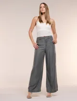 Pantalón wide leg de denim liviano gris, con tiro alto, presillas para cinturón, bolsillos laterales y corte recto de piernas anchas.