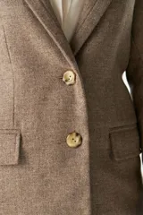 Blazer largo color crema con cuello solapa, bolsillos con solapa y forro interior combinado a tono. Confeccionado en lana fina sin teñir.