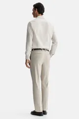 Camisa de vestir color beige claro, de manga larga, con cuello inglés y cierre de botones. Presenta un corte slim fit y bajo ligeramente redondeado.