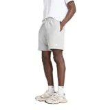 Short deportivo gris melange de algodón y poliéster reciclado, con cintura ajustable con cordón, bolsillos laterales y bolsillo trasero. Logo de New Balance estampado en blanco en la pierna izquierda.