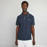 Remera polo azul marino de piqué de algodón, con cuello clásico con ribete blanco, tapeta de dos botones y mangas cortas con ribete blanco.