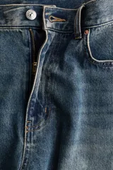 Jean de cinco bolsillos en denim de algodón, de cintura estándar, diseño curvo y corte holgado con efecto desgastado.