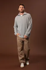 Sweater verde oscuro de punto con cuello alto y cierre de cremallera parcial. Tejido de canalé vertical.