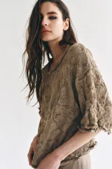 Jersey de punto color tostado con cuello redondo y mangas por debajo del codo, confeccionado con un diseño de tejido con efecto arrugado y corte holgado.