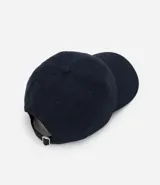 Gorra azul marino de sarga con visera curva, ajuste trasero y bordado rojo con la palabra "amour" en el frente.