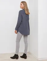Camisa de corte largo y holgado, con estampado de rayas verticales en azul marino y blanco. Presenta cuello con solapa, cierre frontal con botones, bolsillo en el pecho y mangas largas con puños abotonados.