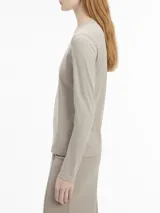 Remera gris de algodón regenerativo, corte slim, cuello redondo y manga larga. Logo pequeño de Calvin Klein debajo del cuello.