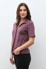 Camisa de manga corta color ciruela, con cuello polo y botones frontales.