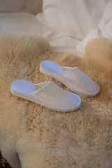 Pantuflas blancas con textura acanalada y plantilla celeste.