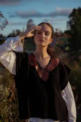 Chaleco tejido negro con cuello en V y aplique de cuero marrón.