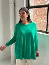 Sweater de punto color verde, con cuello redondo, mangas largas con puños acanalados y diseño holgado con detalle de costura vertical central.