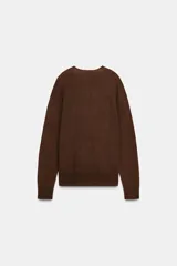 Jersey de manga larga confeccionado en hilatura de lana 100%, con escote en pico y acabado de punto fino.