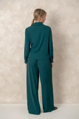 Pantalón de corte recto y tiro alto, con diseño holgado, bolsillos laterales y cintura elástica.