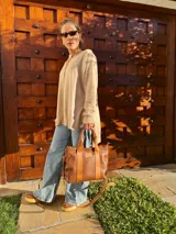 Buzo de tejido de punto color beige, de corte holgado y mangas largas.