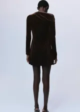 Vestido corto entallado de terciopelo marrón con aplicaciones de brillos, cuello asimétrico de un solo hombro y manga larga.