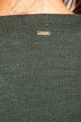 Chaleco verde militar con escote en V, corte al cuerpo y cierre frontal con botones marrones.