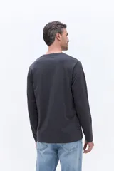 Remera de manga larga color gris oscuro, con cuello redondo y estampado frontal con la frase 'Unlimited Adventure'.