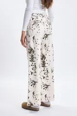 Pantalon de jean de corte ancho y tiro medio, color crudo con estampado de manchas irregulares en tonos oscuros. Presenta un diseño de pierna recta y ruedo desflecado.