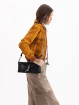 Mini bag de cuero vacuno color celeste con herraje metálico de candado y llave, y correa de hombro ajustable.