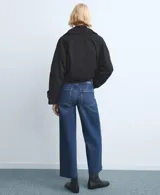 Jeans de denim azul oscuro con corte recto y tiro medio, con bolsillos clásicos y terminación recta en las piernas.