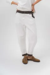 Pantalón de gabardina azul marino, de corte barrel y tiro bajo, con detalles en pana marrón en la pretina y en el ruedo interior vuelto.