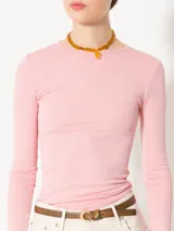 Remera de punto con textura suave, manga larga y escote redondo. Presenta un diseño ajustado al cuerpo con espalda abierta y largo a la primera cadera.