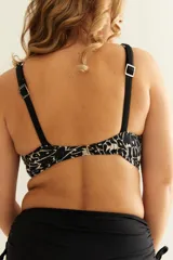 Top de bikini estampado en blanco y negro, con breteles regulables, nudo central y broche en la espalda.