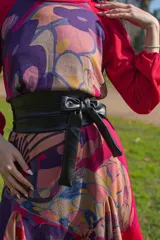 Faja ancha de cuerina negra con lazo al frente.